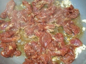 step3: 熱油，落一半蒜茸炒香，落牛肉。
如想牛肉可囗，落牛肉後，用煎嘅方式煎香兩面，切勿不停兜。見兩面牛肉金黃，肉色仍有少許粉紅，連肉汁盛起後用。