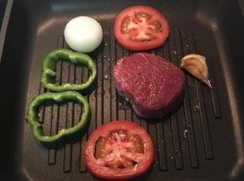 step4: 牛排鍋燒熱後加適量橄欖油，將牛里肌、蒜頭、洋蔥、青椒圈和蕃茄圈放入煎煮，並撒上適量的鹽和黑胡椒粉調味。蕃茄易熟，所以兩面快煎即可起鍋備用。