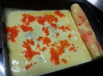 step3: 用筷子慢慢將蛋卷起,將以卷起之蛋推向前方,再倒入薄薄蛋漿,再加入適量蟹籽,如此類推做出多層