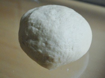 step5: 將麵團放在灑有麵粉的枱上，大力搓麵團10分鐘，起初麵團會較黏，但搓約五分鐘後會開始變幼滑（如太黏，太濕潤，可加少許高筋麵粉）當搓麵團至五分鐘，加入切成小塊的牛油在麵團內，繼續搓