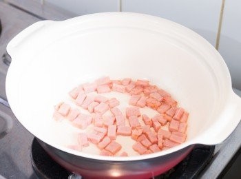 step2: 以中火燒熱鍋子，加少許食油，油熱後加入火腿粒炒至表面金黃色。