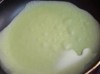 step9: 6寸平底鍋燒熱，搽少許油，倒入一勺斑斕粉漿約30g，拿起平底鍋將粉漿沿周圍攤開，小火煎至可以用瓁鏟鏟起餅皮