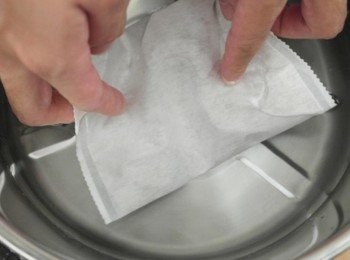 step3: 將水倒入容器中...我用大同電鍋的內鍋=0= 雙手洗乾淨後把愛玉包放入水中... 以順時針方向均勻搓揉約7分鐘~~像洗衣服那樣!!