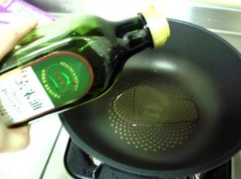 step2: 鍋子燒熱加入1大匙麻油和1大匙黃金玄米油，放入老薑片、辣椒片以小火煸炒出香味。