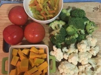 step1: 煮滾ㄧ鍋水，期間處理蔬菜，先在大蕃茄的屁股劃個叉叉，花椰菜淨洗乾淨，去除較老的皮和莖備用。南瓜去皮切小塊後蒸20分鐘。