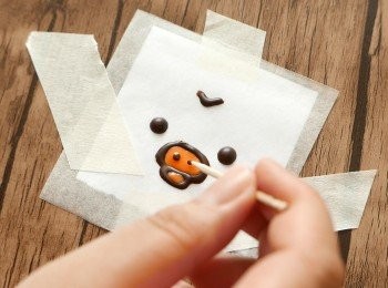 step20: 待上一個步驟的朱古力凝固後，用橙色朱古力填上顏色，然後待橙色朱古力凝固後，再用黑色朱古力點上阿雞的鼻孔。