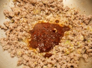 step3: 接著將豬肉撥開，加入蔥、薑、蒜末炒香，接著放入豆瓣醬炒香，並從鍋邊熗入米酒。