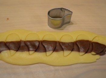 step11: 做尾巴，取適量深啡色麵糰和原色麵糰揉成長條，並間隔排放好後擀平，然後用模具壓出尾巴，蘸一點蛋液將尾巴拼在一起。