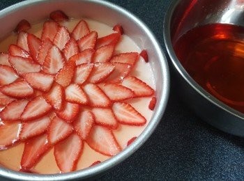 step12: 將士多啤梨片平鋪在已凝結的慕絲層上，倒入少許啫喱水，移入雪櫃雪凝固