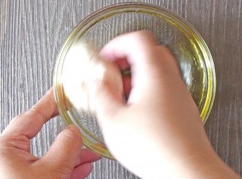 step6: 拿起麵團，把橄欖油倒在碗中。用麵團表面把油在碗中塗抹開。