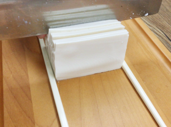 step4: 然後用菜刀切豆腐，切到筷子就停。（小心切到最後會傾斜）