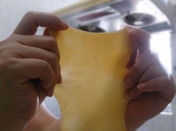 step10: 預備一鍋滾水，下少許油和鹽，下麵皮前，先用雙手將麵皮拉扯，然後放入滾水中（小貼士：這樣烚出來的麵皮會更薄一點）