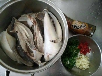step2: 然而，魟魚是少數的軟骨魚類，回來需要用菜瓜布或刷子將魚皮上的黏液、髒污雜質刮除乾淨，最後用水清洗乾淨即可並切一半。(若擔心有阿摩尼亞味道的腥味，可以用米酒醃一下魟魚來去腥)。蒜頭敲碎、青蔥切珠、辣椒切碎，醬油，備用；