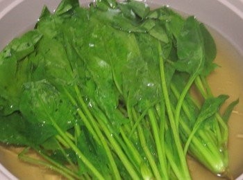 step2: 菠菜用沸水焯熟，切去菜頭(根位)用布巾包起渣掉水份
再中間切開分成2段