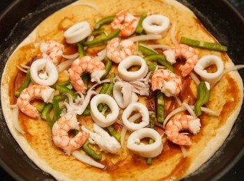 step8: 接著先在<span class="group_2">餅皮</span>上抹上照燒醬，再來依序灑上洋蔥絲、青椒絲、蝦仁與透抽。