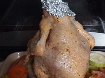 step3: 用廚房紙將醃好的雞稍為抹乾，在頸項位置包上錫紙(避免燒焦和蒸氣散出)，下方套入啤酒罐，放到焗盤中間(注意平衡，不要讓雞跌到)。喜歡蔬菜的話可切薄片鋪在焗盤上，雞油滴下會滲到蔬菜裡