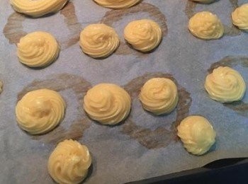 step4: 烤箱預熱到210-220度。 將擠花袋裡的麵糊擠在已鋪了烘焙紙的烤盤上，尺吋約為2-3公分的圓型，每顆間要留間格。擠好後手指沾水將尖端的地方輕輕壓圓即可。