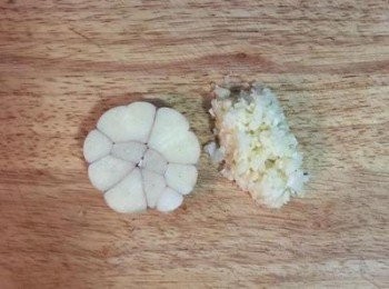 step2: 蒜頭對切後，上半部散開的部份拍扁去皮切成蒜末。下半邊則完整留下備用。