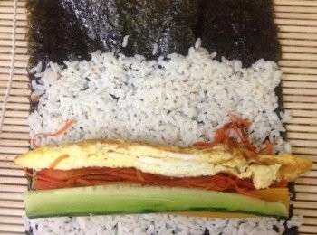 step6: 6. 將紫菜 (光面向竹墊) 放在竹墊上, 將白飯平均鋪在紫菜上。