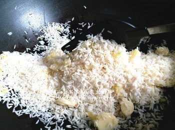 step13: 煲湯期間將薑片 , 蒜頭放入鑊中炒香 , 再加入白米炒至乾身
