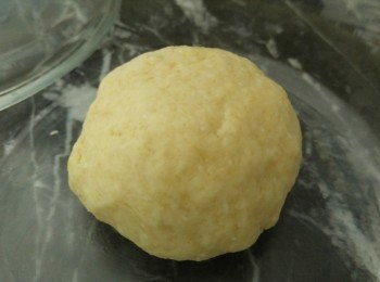 step2: 將高筋麵粉過篩後放入大器皿後加入酵母,奶,鹽,糖,溶牛油攪勻後,拿出搓成光滑後,放入巳塗油的大碗然後包保鮮紙放入微波爐發酵(不需開動微波爐的),發酵45分鐘,拿出靜止10分鐘,枱面撒上高筋麵粉用木棒壓平到12吋,邊緣越薄越好。預熱焗爐250度