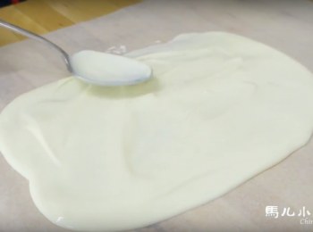 step4: 鋪一張烘焙紙，把巧克力倒出來在桌上，巧克力來回抹平