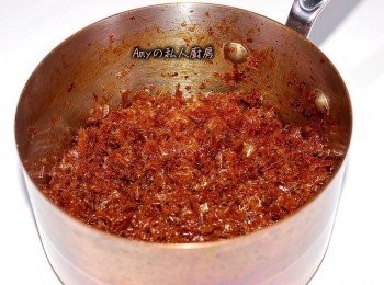 step4: 一直拌炒到焦糖香出現,此時柴魚片的顏色會因湯汁收乾而變深,可使用剪刀在鍋子裡將柴魚片剪成小塊狀(這樣會更有口感),加入芝麻香油拌炒