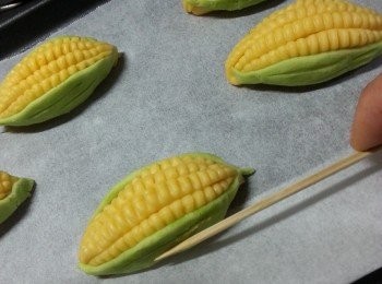 step13: 將粟米排好在舖了牛油紙的焗盤上,用竹籤將菜畫上葉紋
