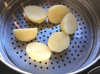 step2: 薯仔去皮，切開一半，隔水蒸十五至二十分鐘，直到薯仔煮至熟透。隔水蒸，而不下水煮，可以避免薯仔吸收太多水份。薯仔也可以連皮用焗爐烘熟。