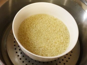 step2: 小米先洗乾淨後，放入中碗，今天的水分要多ㄧ點，因為香蕉和芝麻黏稠度高，等一下做寶寶吃的部分小米粥要稀ㄧ點，然後蓋上盤蓋，電鍋外鍋3杯水，慢慢燉煮。