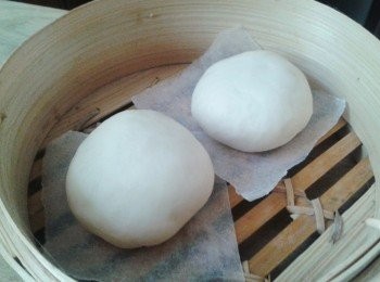 step5: 將包子放在烘焙紙上，放入蒸籠內，蓋上蓋靜止25分鐘作第二次發酵 （麵團會再發大一點）