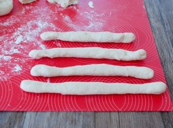 step4: 拿出麵糰，用手按壓排出空氣，將麵糰分成8等份。將麵糰擀成長條狀