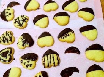 step6: 把45克的巧克力放入大碗內隔熱水溶化，巧克力溶化後，把大碗從熱水上移走並把剩餘的巧克力加入並攪拌，直至它完全融化。取一塊曲奇浸在溶化的巧克力中，直至所有曲奇都蘸上巧克力。將其放置在烘焙紙上直到巧克力硬化。