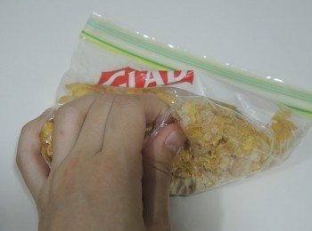 step3: 粟米片隔着包裝袋或放入保鮮袋，用手大致壓碎。雞蛋打散。