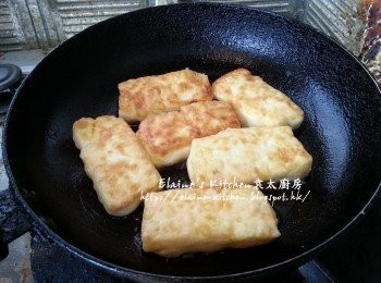 step11: 將豆腐從雪櫃取出後每件沾上麵粉 , 放入鑊中用慢火慢慢煎至兩面金黃色