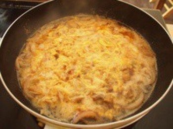 step6: 雞肉煮熟後轉成大火，均勻地以打圈的方式淋上一半的蛋液，蓋上鍋蓋燜半分鐘，再打開蓋子淋上剩下的蛋液後熄火，用鍋子餘溫把蛋液加熱成半熟狀態