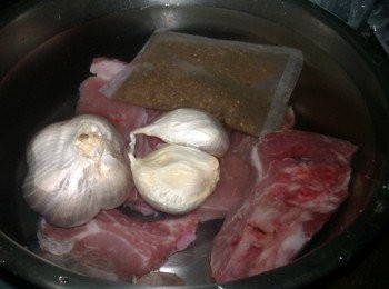 step3: 連同清洗過的大蒜頭+小蒜頭和肉骨茶包，放入湯鍋中9分滿水並再加入2大匙醬油