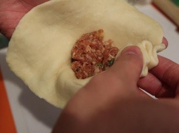 step7: 放入內餡，右手大拇指按著不動，另外四指推移前進，使褶皺繞一個圓圈。