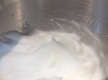 step4: 將<span class="group_2">蛋白霜</span>中的糖霜分兩三次加入蛋白中，一邊用電動打蛋器高速打至蛋白顏色變雪白﹑表面光亮﹑泡沫細緻穩定，用打蛋器拉起蛋白時可拉出直立的尖端