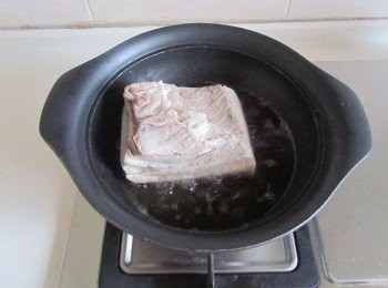 step5: 涼後在廚房紙巾上控幹水分， 燒熱鍋，放入適量的油，將五花肉肉皮向下放入裡面去炸；