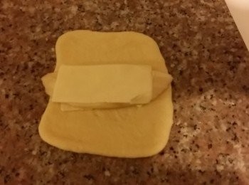 step4: 完全的麵糰開動包機攪20秒左右排氣。取出很再略排氣。把重量除以9，分切開約51-52g一個，滾圓，靜止10分鐘左右。
包入芝士茄子，封口向下。
第二次發酵一小時或一倍大。