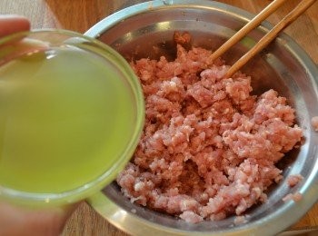 step7: 然後分幾次倒入薑蔥水100ml ，順一個方向拌勻，攪至肉漿吸水充足，肉質起黏性，再加入適量麻油拌勻。