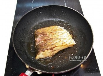 step3: 用2茶匙油爆香2片薑，待薑的香味釋出後，把薑取走，放鯇魚(皮向下)落鑊煎至金黃色，然後再煎另一面。