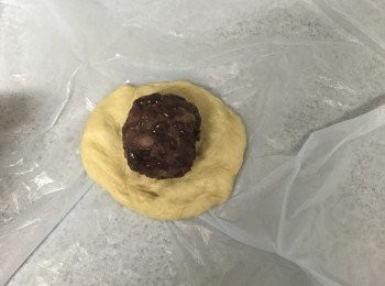 step5: 麵團用木棍壓開，放入[步驟4紅豆蓉]，包裹後收口朝下放到烤盤上。