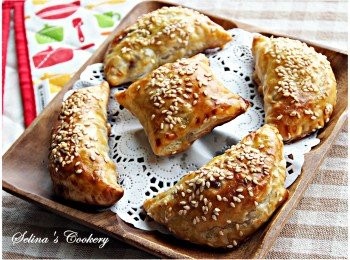 step5: 放置在鋪了烘培紙的焗盤中，酥皮表面掃少許蛋汁，用叉在上面插兩三個小孔，灑點白芝麻；然後放入已預熱的焗爐中，焗約15至20分鐘，或直至表面呈金黃色，即完成;