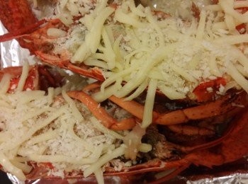 step2: 龍蝦溶雪後取肉,龍蝦頭用微波爐叮一分鐘,將雪水倒掉,將蝦肉切大件放入蒜蓉略炒,將龍蝦肉煙肉碎釀入龍蝦殼裏面再鋪上芝士,芝士和麵包糠焗到微燶備用。