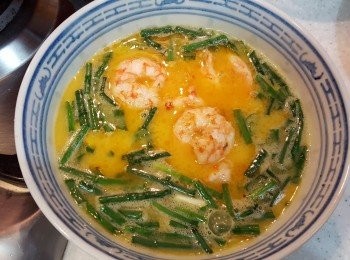 step2: 將雞蛋，雞粉，麻油，牛奶，蔥段打勻，再放下已8成熟的蝦仁段。