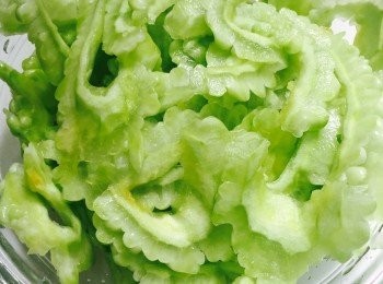 step2: 苦瓜洗淨切半，刮去瓜囊。切去頭尾，切大斜薄片。苦瓜片放碗內，加1茶匙鹽拌勻稍醃約5分鐘，去掉苦瓜的苦味，瀝乾。