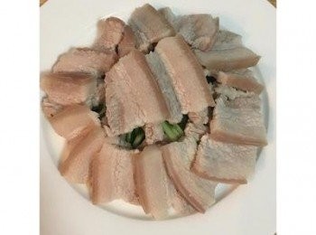 step6: 取出冰鎮小黃瓜，將肉片依續疊放在小黃瓜絲上。<span class="group_2">蒜泥醬</span>中加入蔥花，略拌勻後淋在擺好的五花肉上。中間放上香菜和巴西里葉做裝飾即可。