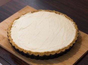 step14: 組合：之後放上打發好的淡忌廉鋪平，平均灑上淨下的檸檬皮屑，如需要裝飾的話可唧上份量外的忌廉，放入雪櫃（refrigerator）約 4 小時以上即成